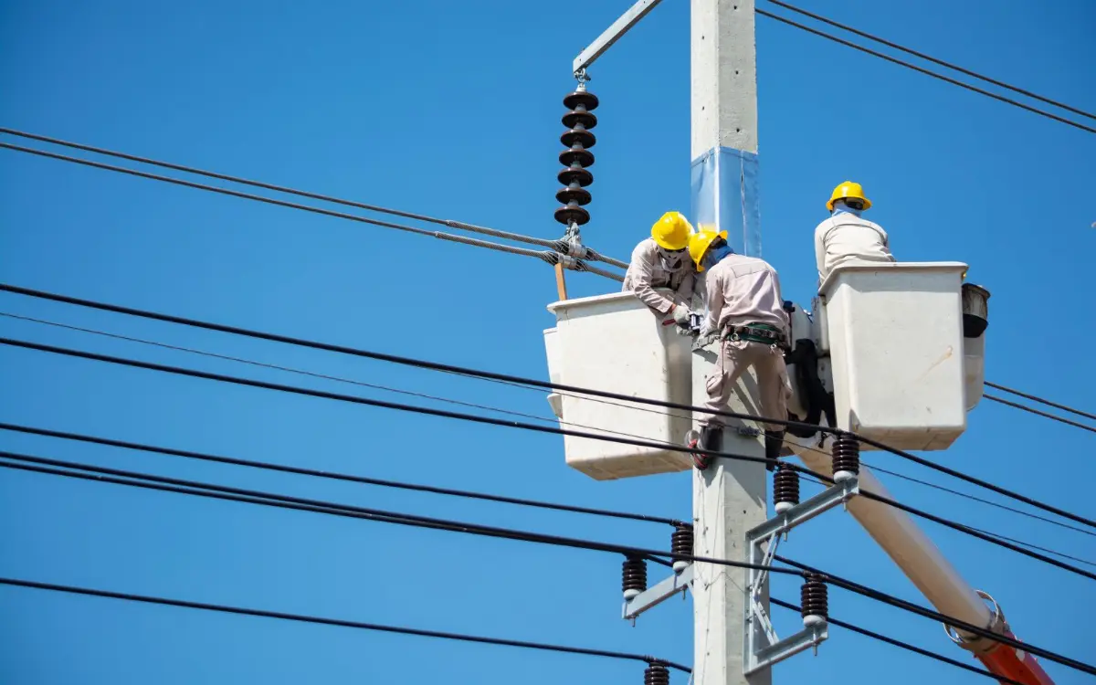 Utility crew in bucket trucks repairing overhead lines