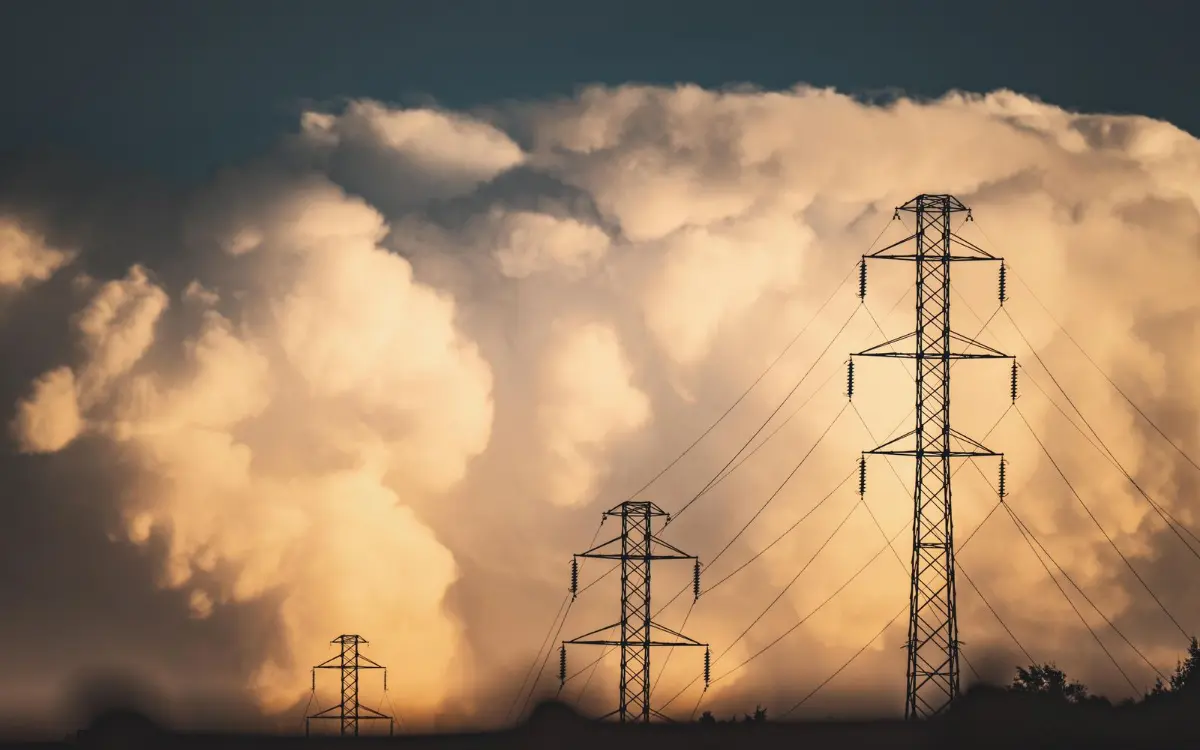 Transmission towers against tall summer clouds