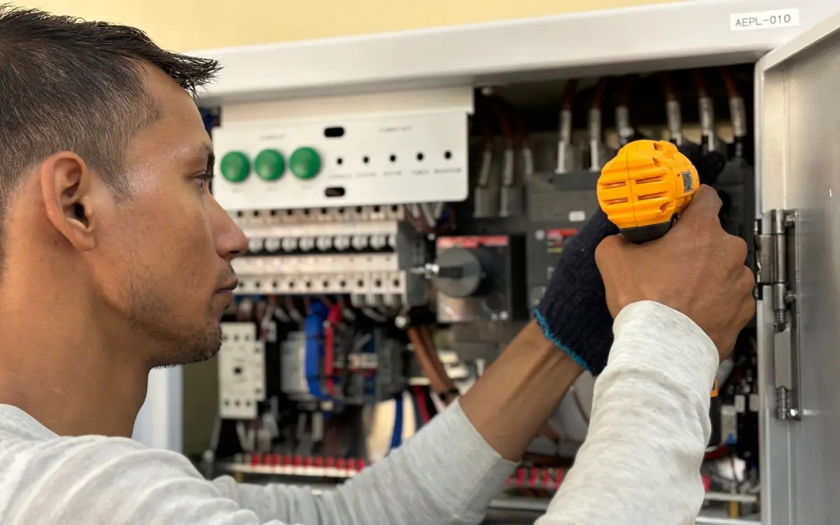 Technician testing breakers inside an electrical panel before a generator hook-up